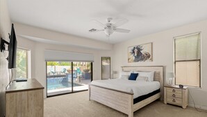 A bedroom with a bed, a nightstand, a TV, and a ceiling fan. - HTD Pool Fire Pit Games Dog Friendly Ping Pong (Chandler)