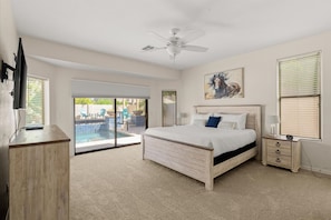 A bedroom with a bed, a nightstand, a TV, and a ceiling fan. - HTD Pool Fire Pit Games Dog Friendly Ping Pong (Chandler)