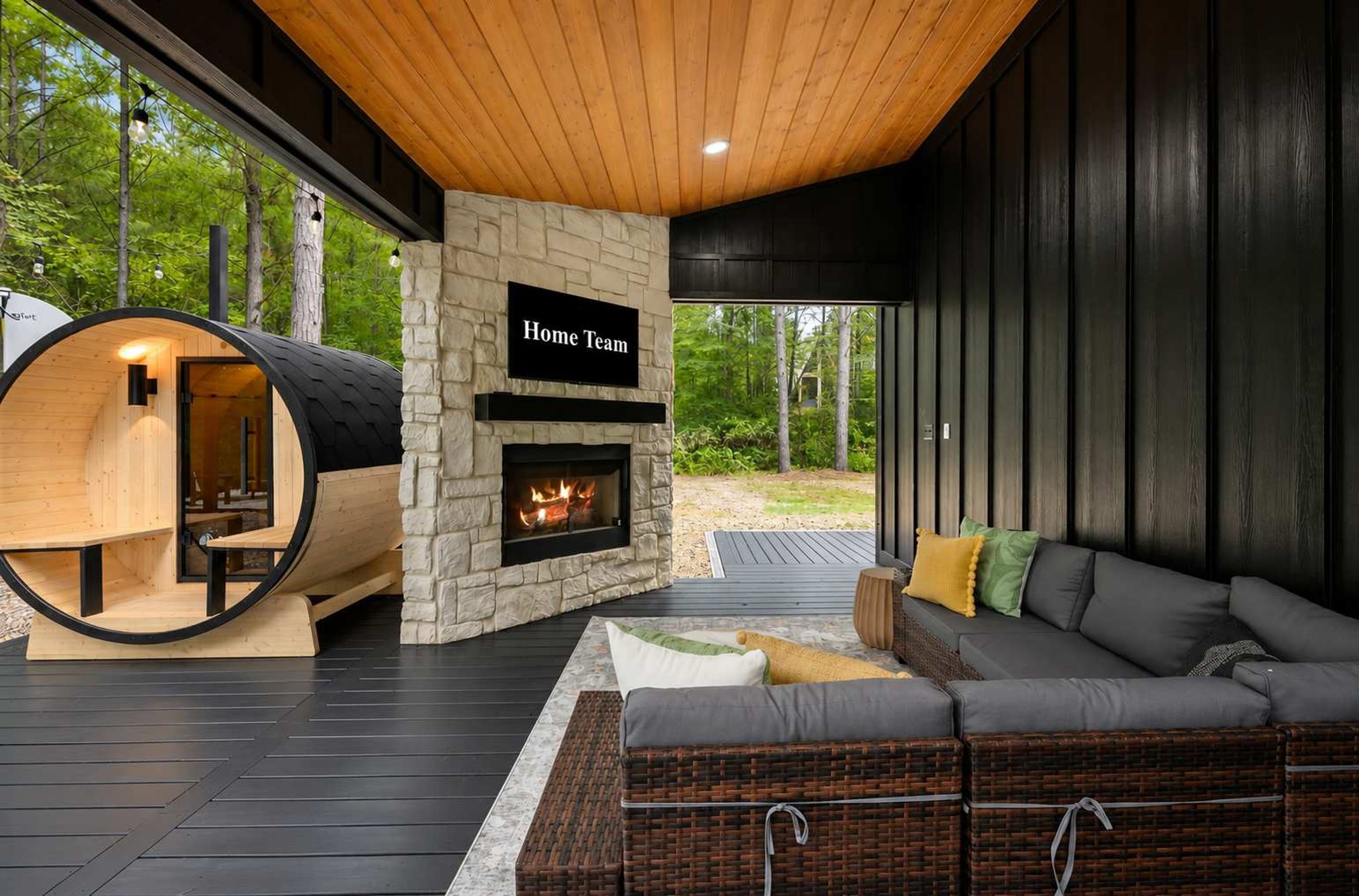 A modern outdoor living space with a stone fireplace, a wooden barrel structure, and a comfortable seating area.