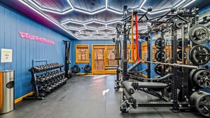 A gym with weightlifting equipment, dumbbells, and a neon sign. - The Smoky Mountain Sanctuary Gym Sauna (Gatlinburg)