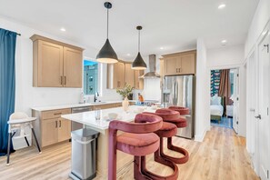 A modern kitchen with a central island, stainless steel appliances, pendant lighting, and a view of the outside. - 4BR Nashville Hideaway - Rooftop Views - Fire Pit (Nashville)