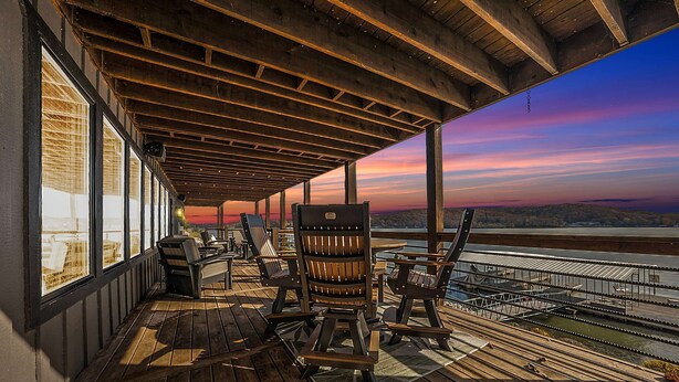 Eine überdachte Terrasse im Freien mit Holzmöbeln und Blick auf das Wasser.