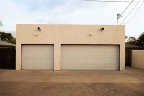 A two-car garage with a plain facade and no visible windows. - The Tucson Bungalow Designer Sam Hughes Retreat (Tucson)