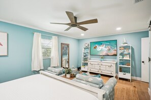 A bedroom with a bed, a ceiling fan, a TV, and a bookshelf. - 4 Br Bradenton Home Private Pool Outdoor Bar W D (Bradenton)