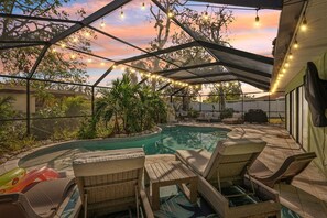 A covered outdoor area with a pool, lounge chairs, and string lights. - 4 Br Bradenton Home Private Pool Outdoor Bar W D (Bradenton)