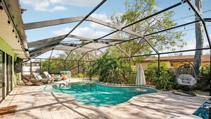 Una piscina cubierta al aire libre con sillones de descanso y un jacuzzi.