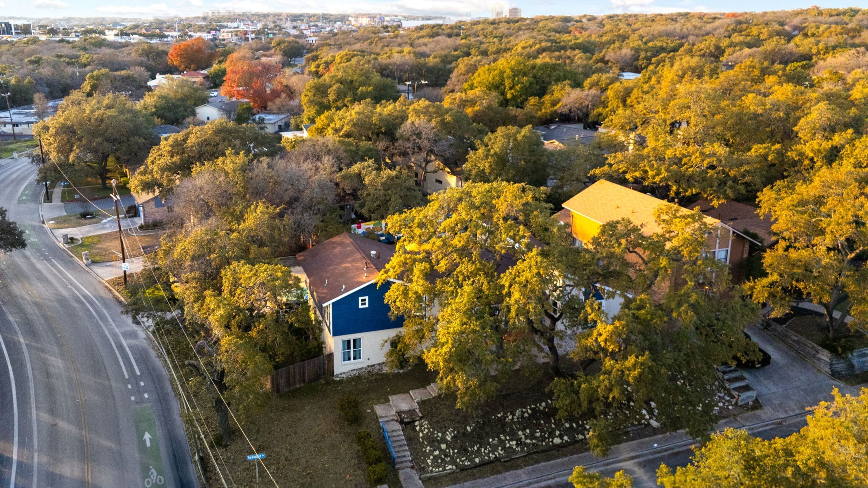 An aerial view of a residential area with houses surrounded by trees.