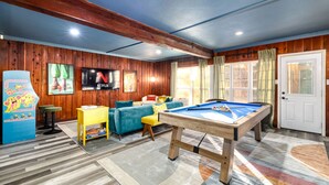 A cozy room with a pool table, wooden walls, and a television. - The Sunburst Sleeps 18 Basketball Heated Pool (San Antonio)