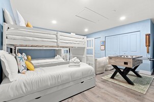 A bedroom with bunk beds, a foosball table, and a door with a keyhole.