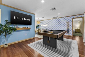 A room with a pool table, a mounted TV, and a blue patterned wall. - Paradise Htd Pool Tiki Bar Hot Tub Games (Seminole)