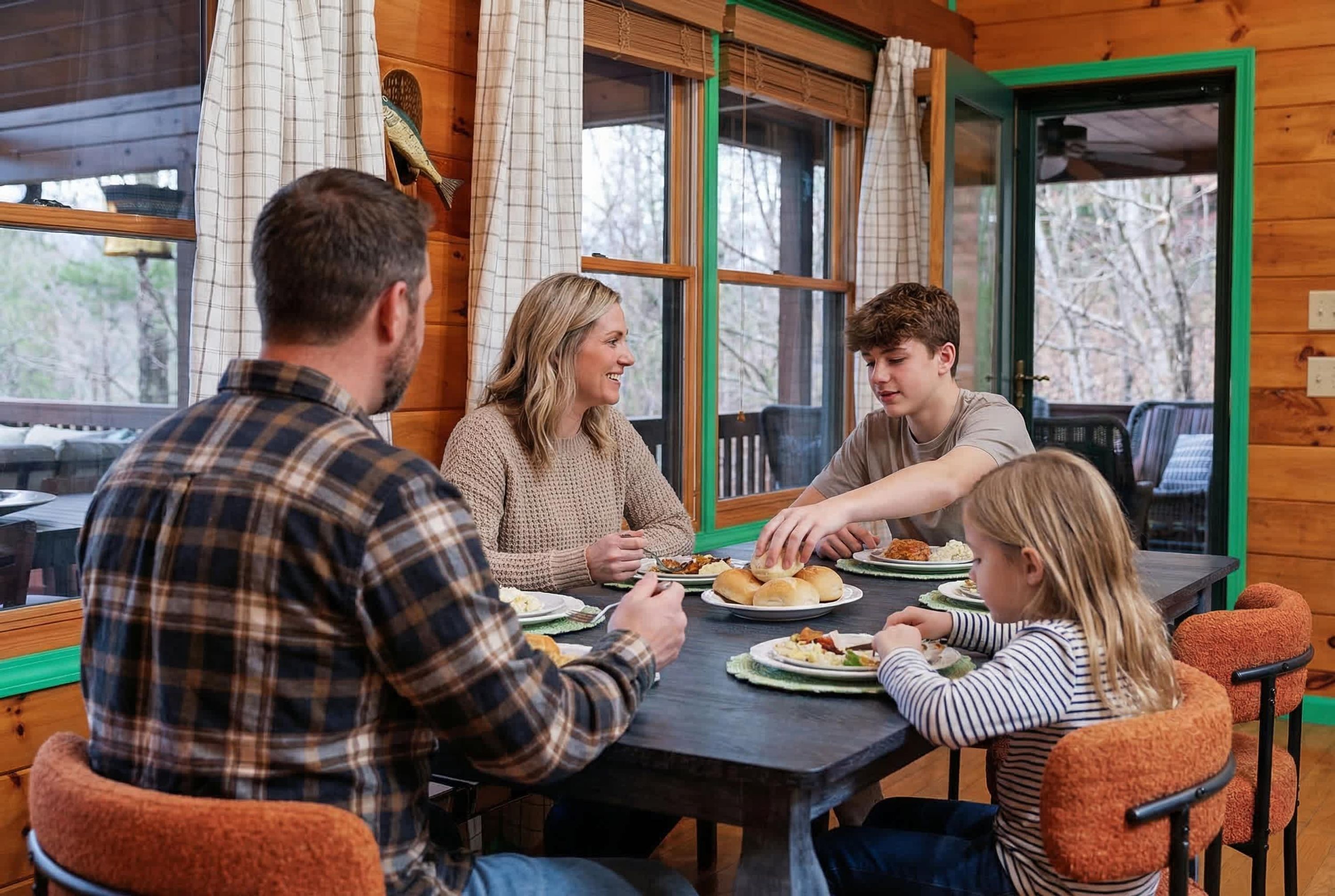 A family dining at a wooden table with a view of trees outside.