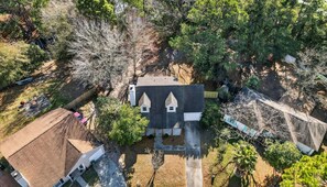 A residential property with a central house featuring a gabled roof and two small attached structures. - Savannah Oasis Hot Tub Pickleball Putt Putt (Savannah)