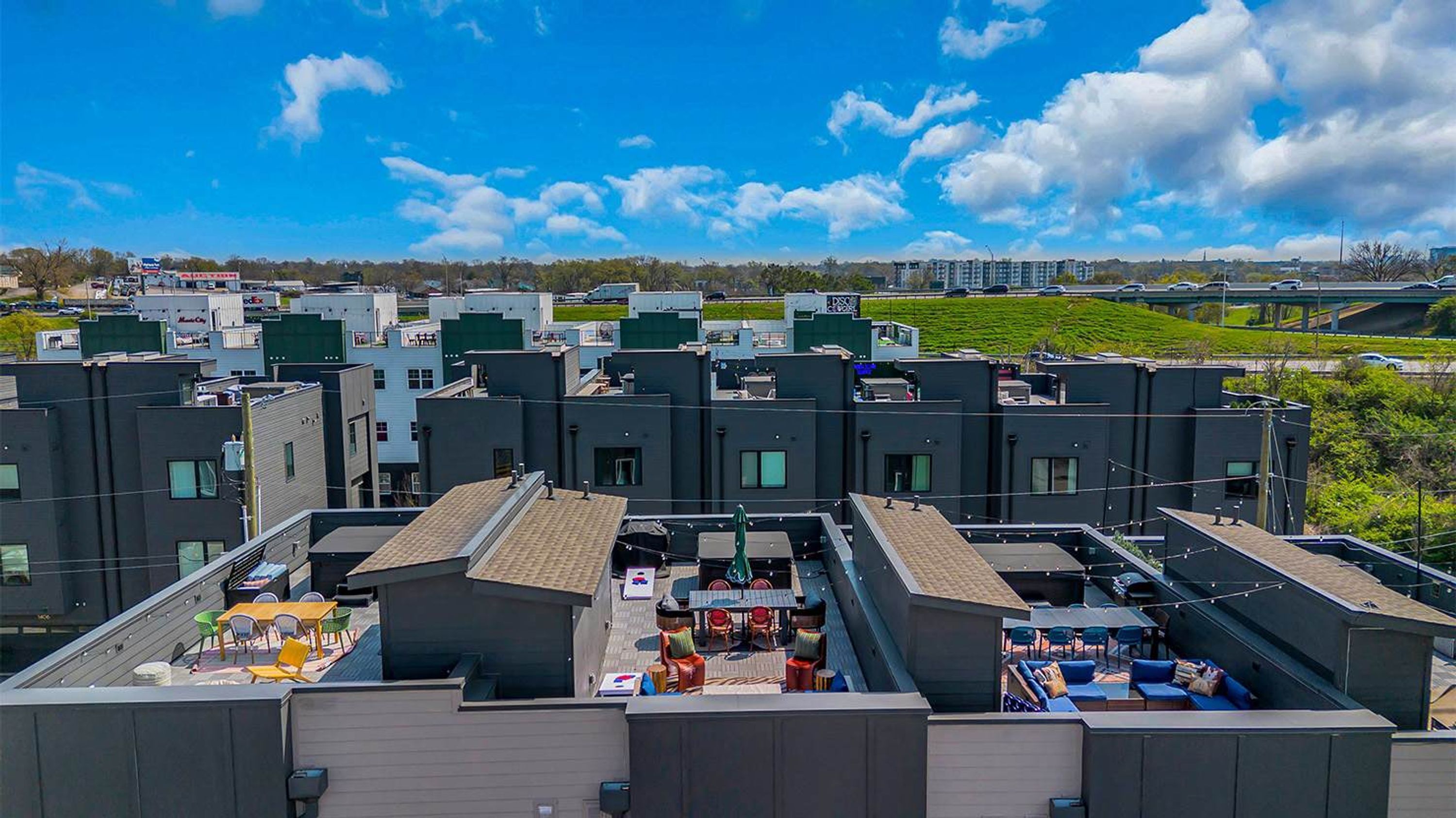 A rooftop terrace with outdoor seating and a view of a cityscape.