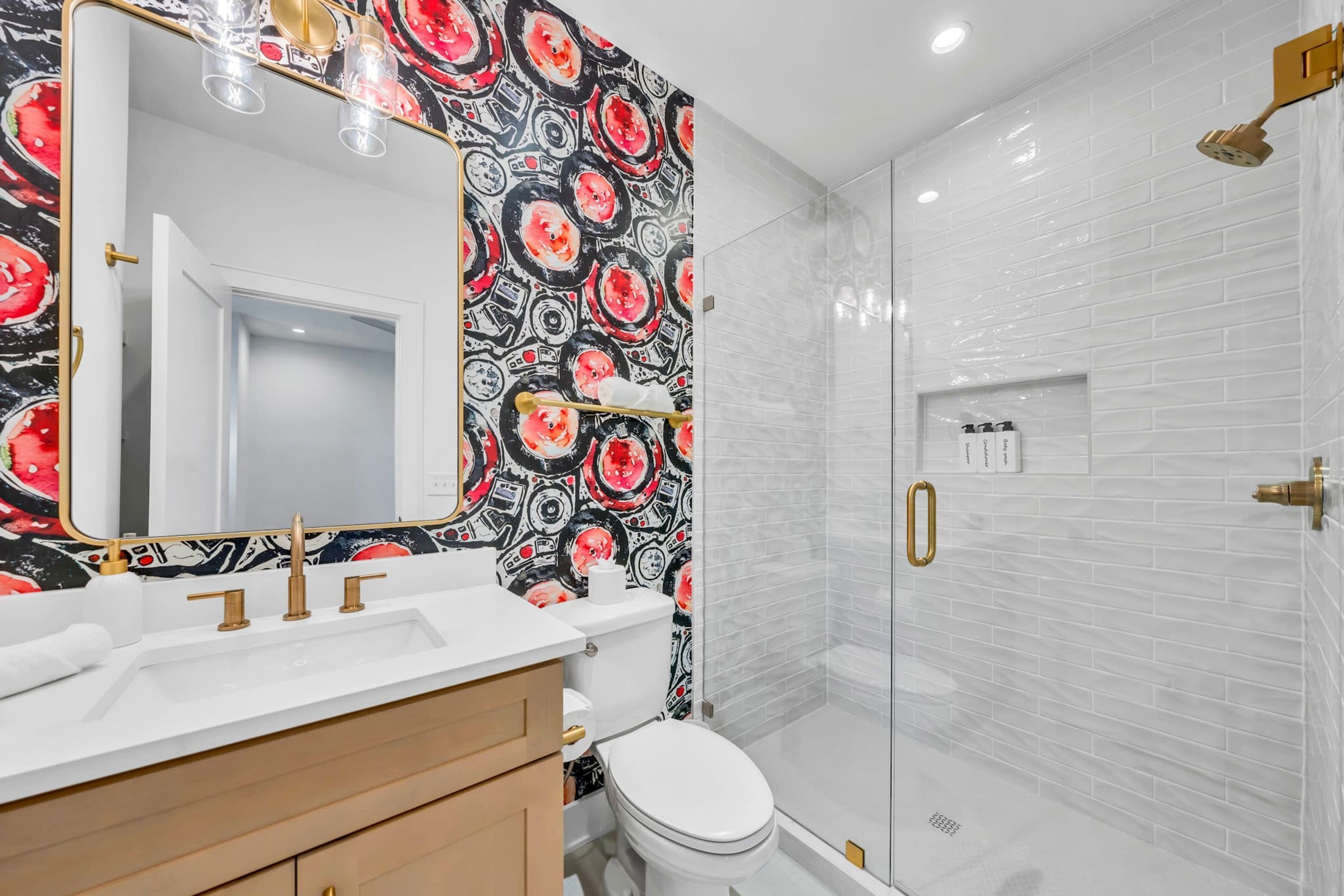 A bathroom with a white sink, a toilet, and a shower with a glass door.