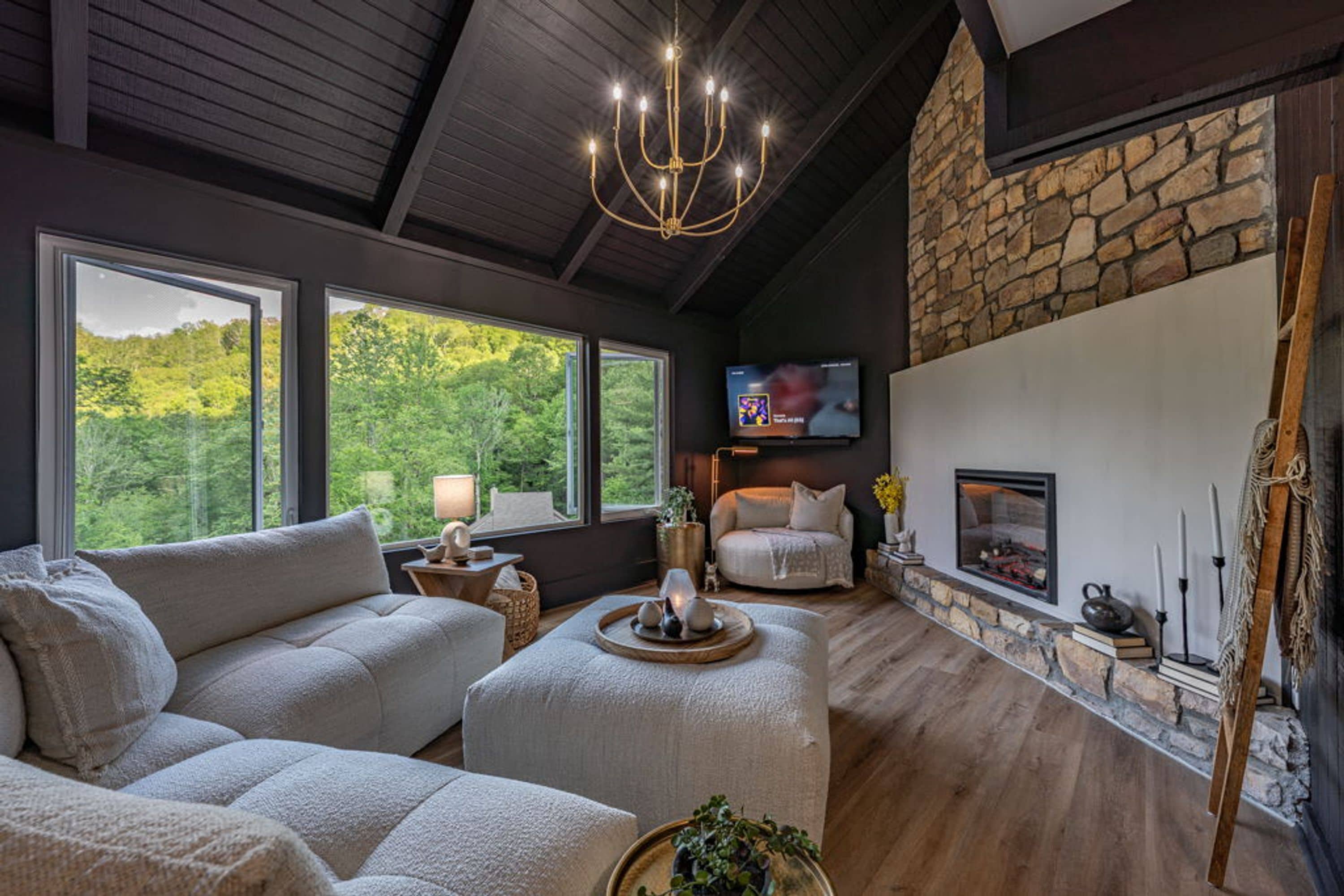 A cozy living room with a stone fireplace, a comfortable sofa, and a television.
