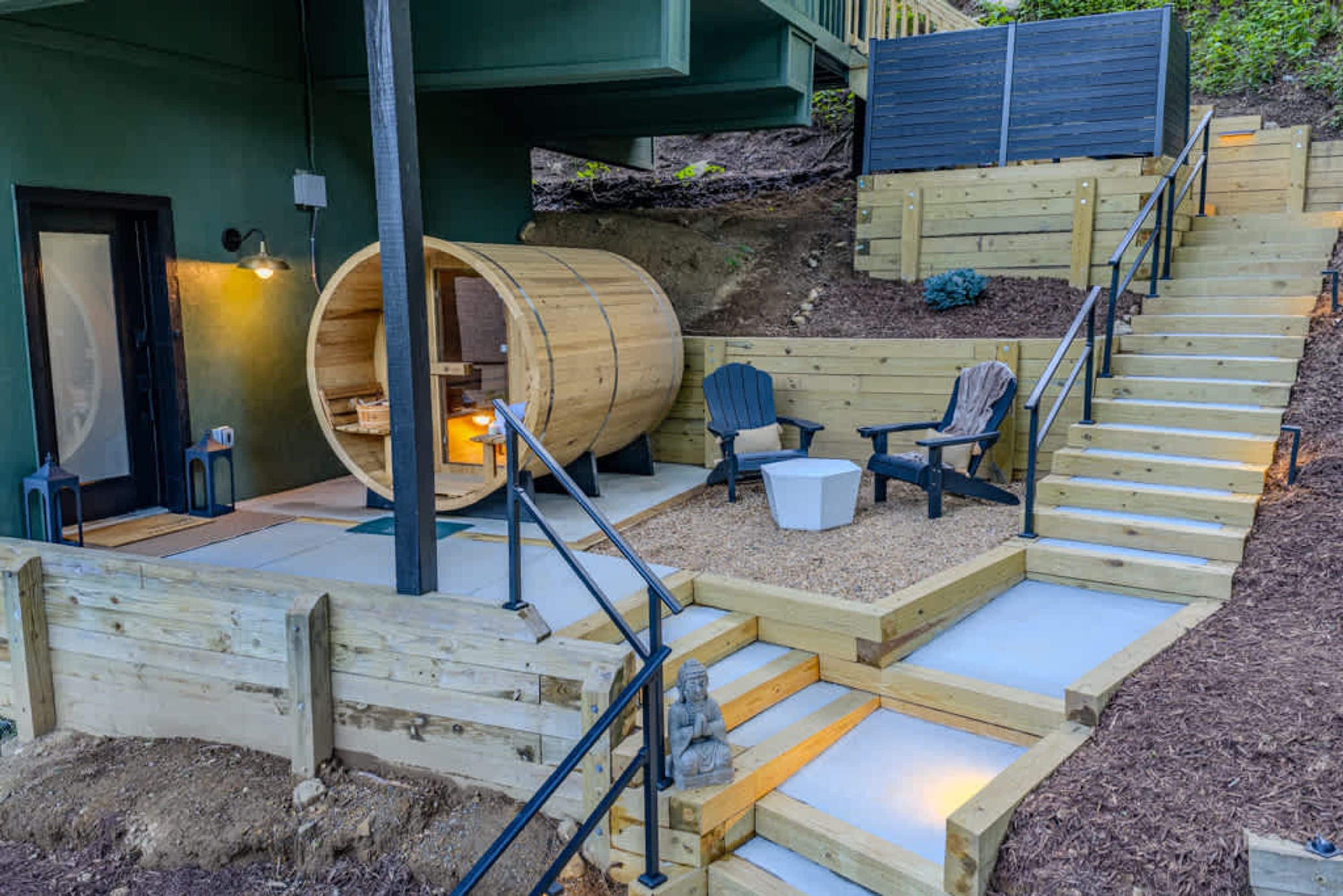 A wooden outdoor area with a sauna, seating, and a staircase.