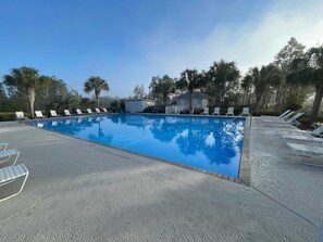 A clear blue swimming pool with white lounge chairs and a small building in the background. - Bella Vacanza Minutes to Beach Community Pool (Gulf Shores)