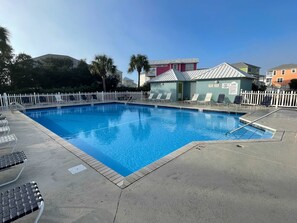 A swimming pool with lounge chairs and a white fence. - Bella Vacanza Minutes to Beach Community Pool (Gulf Shores)