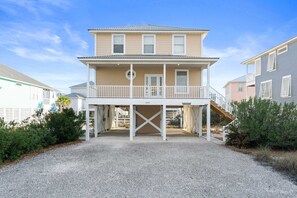 A two-story beachfront house with a covered porch and a staircase leading to the upper level. - Bella Vacanza Minutes to Beach Community Pool (Gulf Shores)