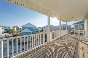 A wooden deck with a white railing overlooking a beach with houses. - Bella Vacanza Minutes to Beach Community Pool (Gulf Shores)