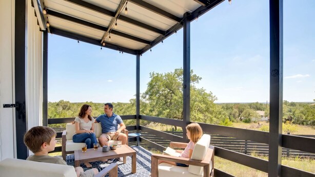 A covered outdoor seating area with a view of a natural landscape. - Hill Country Hideaway Modern Barndominium for 6 (Dripping Springs)