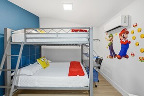 A bunk bed with a ladder, a small table, and a wall with Mario and Luigi wall decals. - Waterfront Heated Pool Home Gym Fire Pit (Tampa)