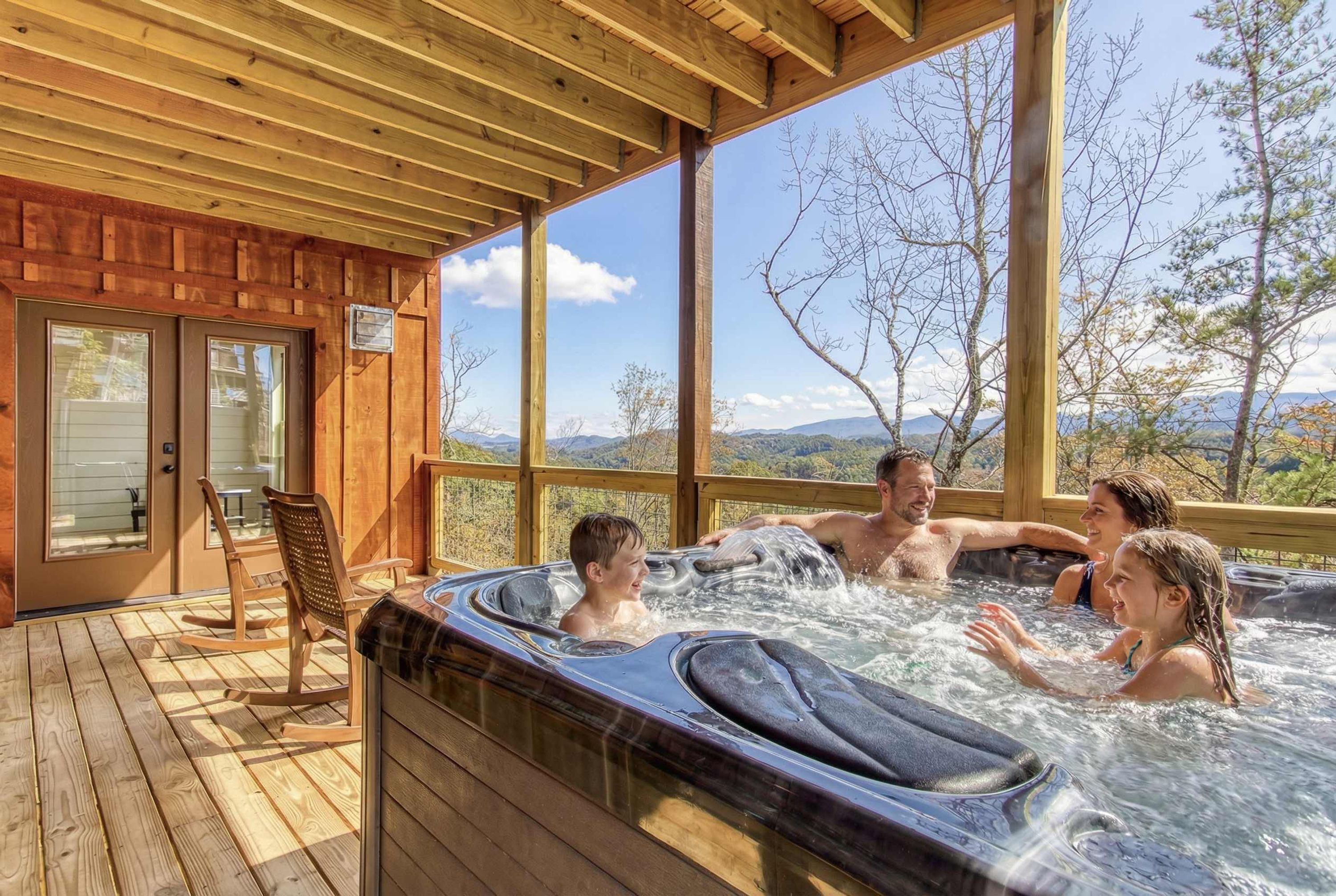 Un bain à remous pouvant accueillir quatre personnes, une terrasse en bois et une vue sur les montagnes.