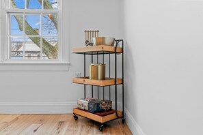 A corner room with a white wall, a window with a view of trees and buildings, and a wooden floor. - Downtown Flat Walk to Dining Shops Sleeps 4 (St. Michaels)