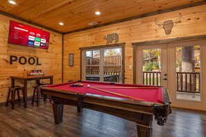 A pool table in a wooden room with a TV displaying streaming services. - Modern Cabin Movie Theater Hot Tub Game Room (Gatlinburg)