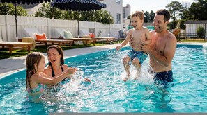 Ein Schwimmbad mit Liegestühlen und Sonnenschirmen.