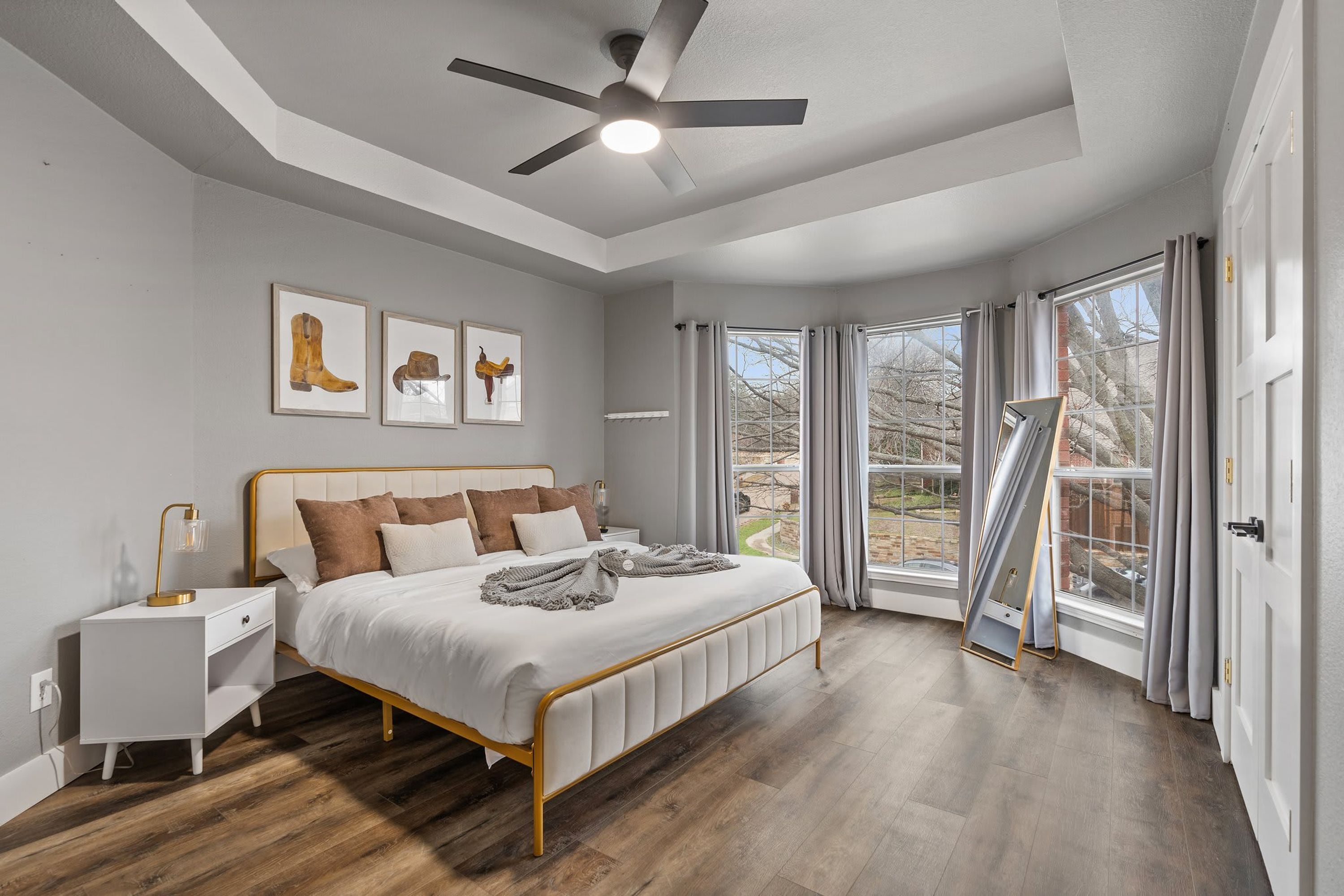 A bedroom with a bed, bedside table, and ceiling fan.