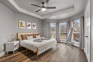 A bedroom with a bed, bedside table, and ceiling fan. - Heated Pool Hot Tub Sleeps 16 Putting Green (McKinney)