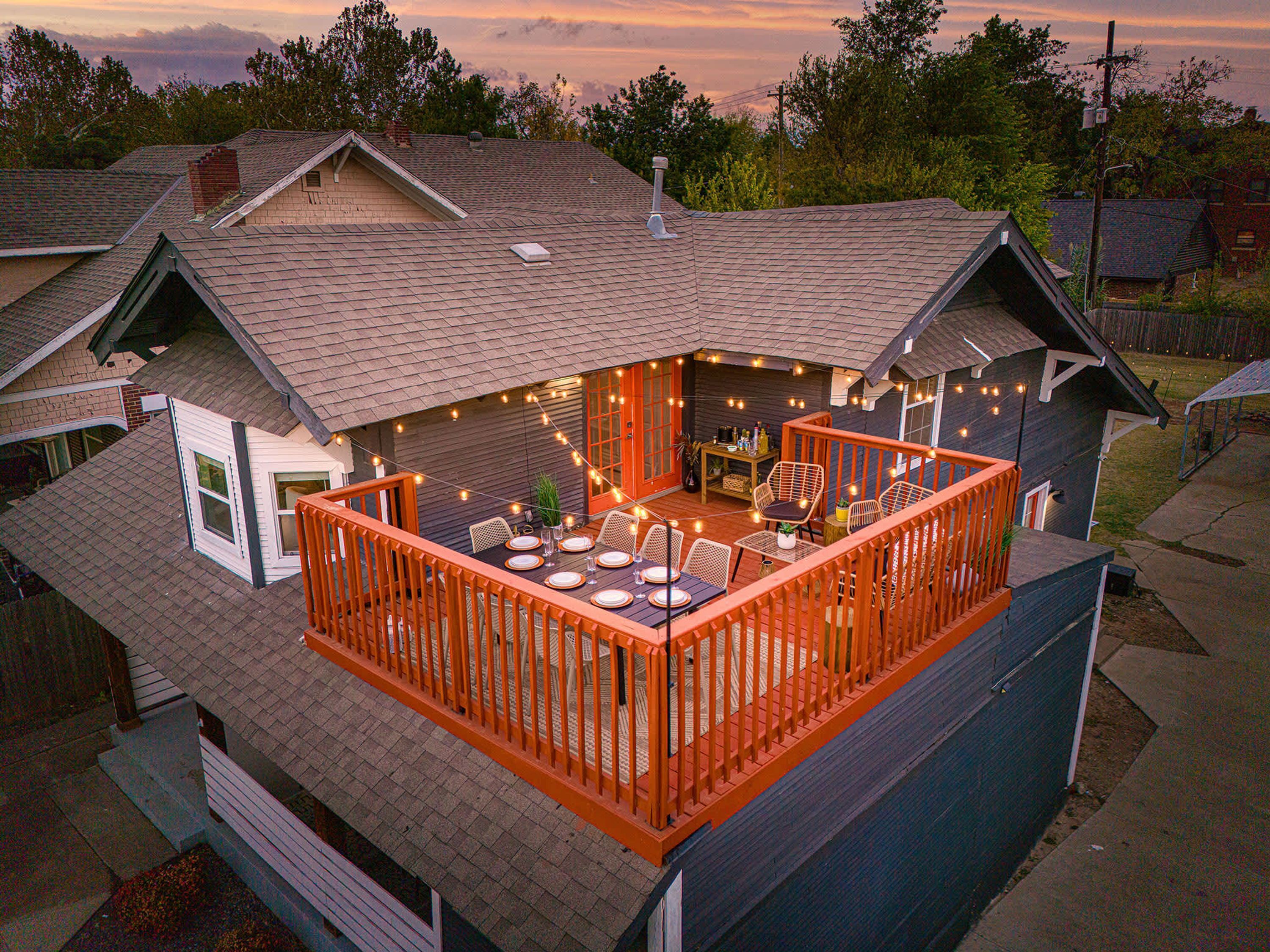 A residential deck with outdoor furniture and string lights.