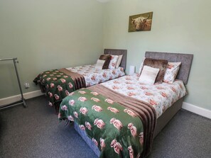A twin room with two beds, each with floral bedding and a headboard. - Prudhoe Cottage (Prudhoe)