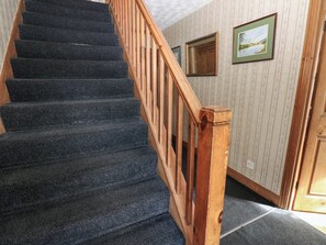 Eine Treppe mit hölzernem Geländer und Teppichstufen.