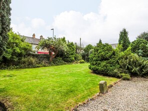 A well-maintained lawn with a gravel path and dense shrubbery. - Prudhoe Cottage (Prudhoe)
