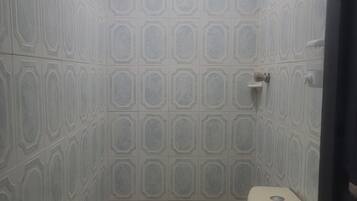 Une salle de bain avec des carreaux décorés, des toilettes et un lavabo.
