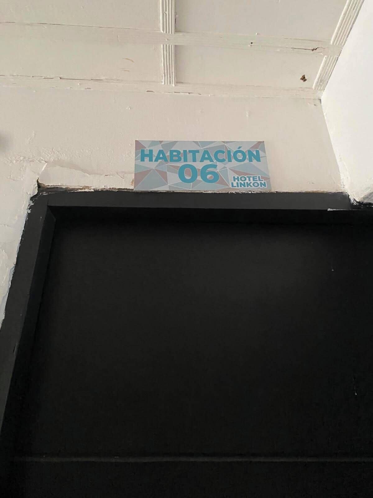 A hotel room door with a sign above it indicating 'Habitacion 06' and 'HOTEL LINAKON'.