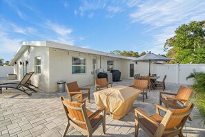 A patio with outdoor furniture, a barbecue grill, and a covered table. - Memory‑Making Sarasota Stay with Heated Pool, Spa & Modern Comfort (Sarasota)