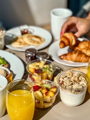 A breakfast setting with various food items and a glass of orange juice. - Family Cottage Torcy (Saint-Thibault-des-Vignes)