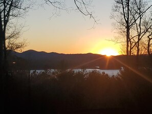 A sunset over a body of water with mountains in the background.
