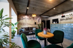 A modern interior with a bar area, seating, and a stone wall.