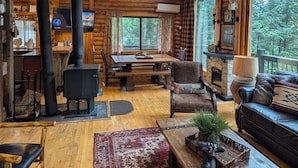 A log cabin interior with a dining area, a fireplace, and a sofa. - Private Mountain cabin, hot tub, 10 min. to Bozeman  10 min. to Bridger Bowl (Bozeman)