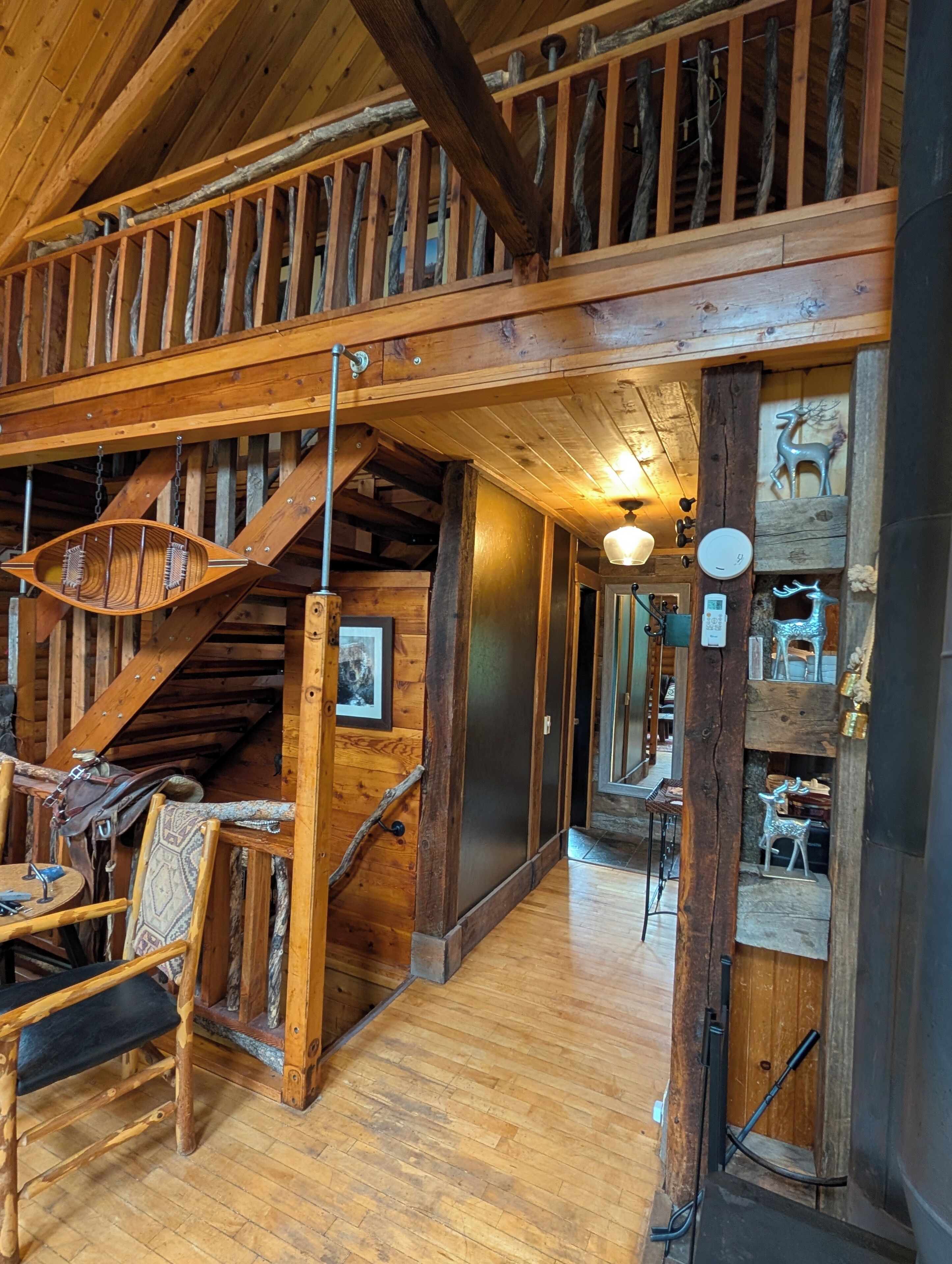 Un interior rústico de madera con escalera, muebles de madera y elementos decorativos.