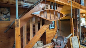 A wooden interior with a staircase, a woven basket, and a saddle. - Private Mountain cabin, hot tub, 10 min. to Bozeman  10 min. to Bridger Bowl (Bozeman)