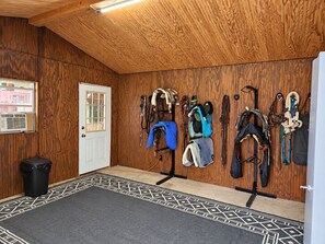 Een stal met houten wanden, een deur en een tapijt met dessin.