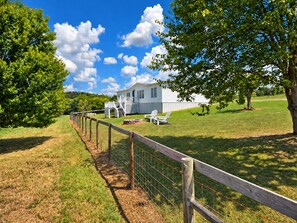 A white house with a porch and a fenced yard. - 47-Acre Farm Stay Near Bell Buckle & TN Whiskey Trail (Wartrace)