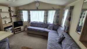 A compact living space with a sofa, television, and a small table.