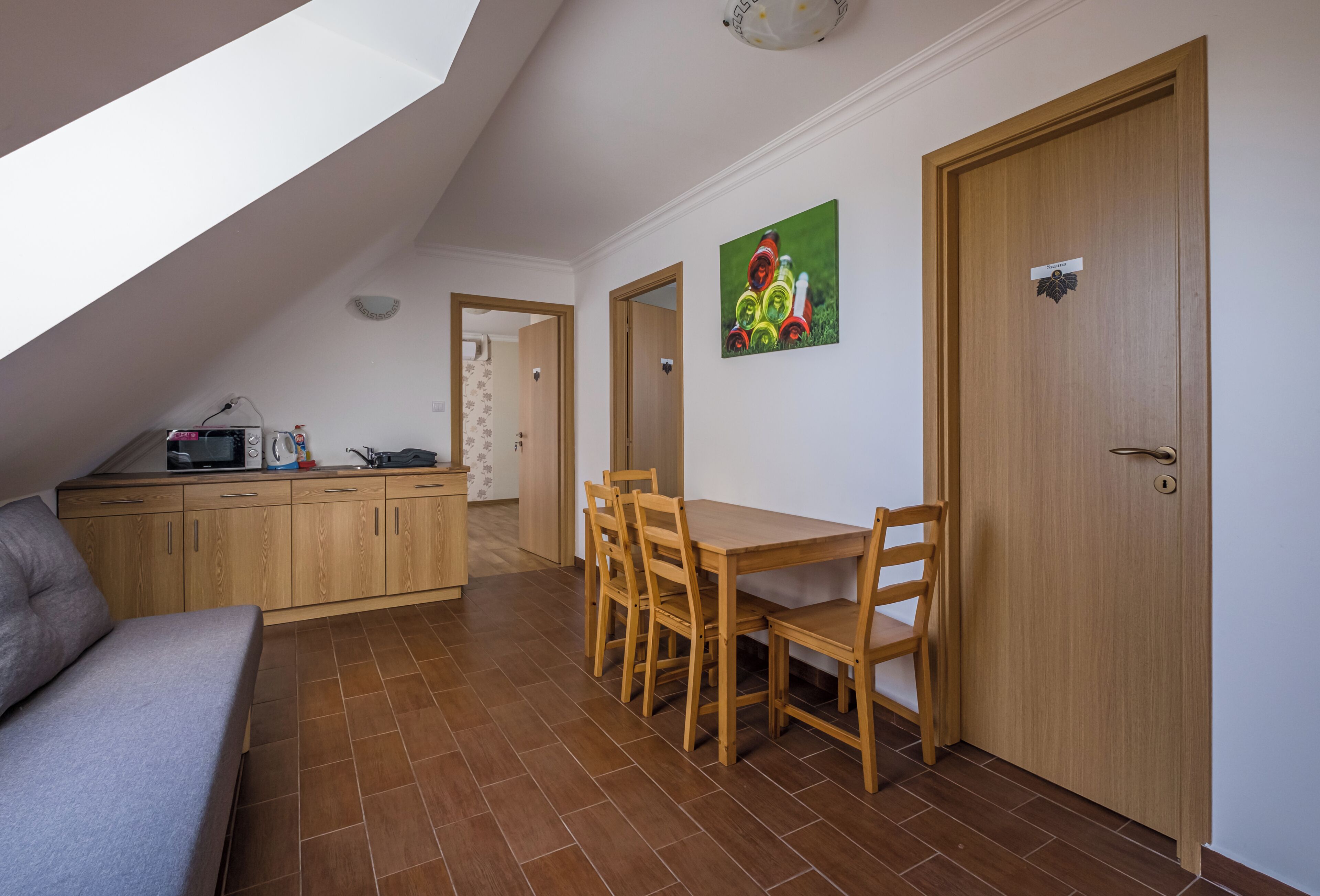 Um espaço compacto com cozinha compacta, área de jantar com mesa e cadeiras, e um sofá.