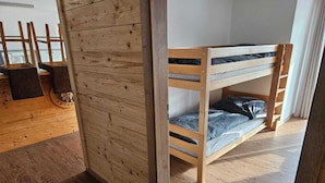 Ein Stockbett mit Holzkopfstück und Matratze.